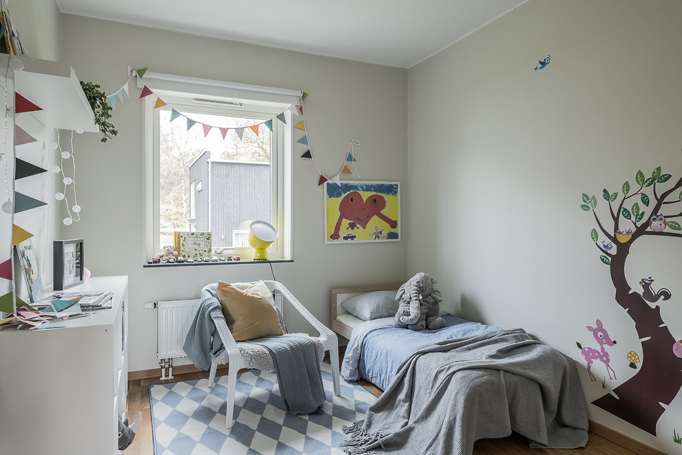 Foto på ett nordiskt könsneutralt barnrum kombinerat med sovrum och för 4-10-åringar, med beige väggar, ljust trägolv och beiget golv