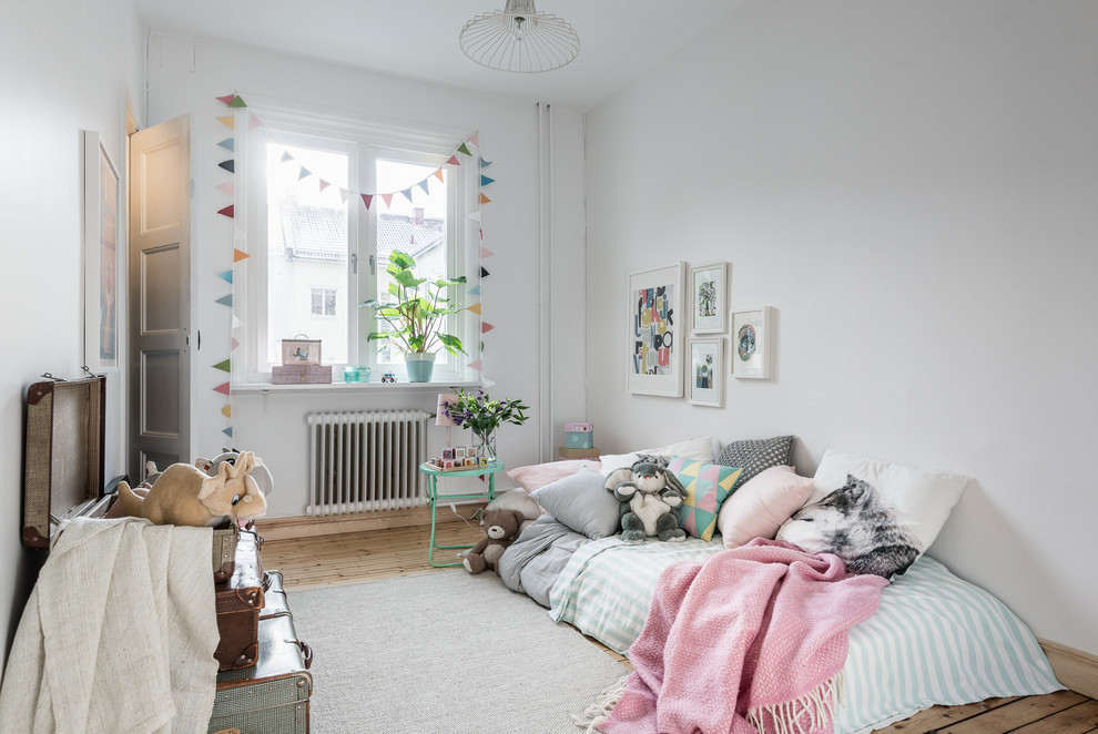 Inspiration för mellanstora skandinaviska könsneutrala barnrum kombinerat med sovrum och för 4-10-åringar, med vita väggar och ljust trägolv