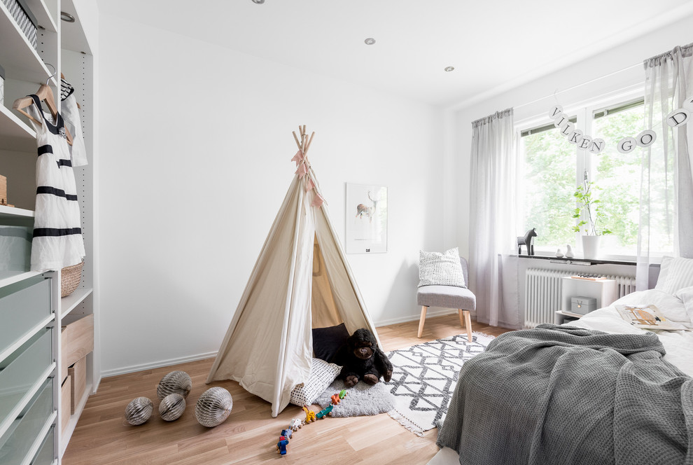 Idéer för att renovera ett mellanstort nordiskt könsneutralt barnrum kombinerat med sovrum och för 4-10-åringar, med vita väggar och ljust trägolv