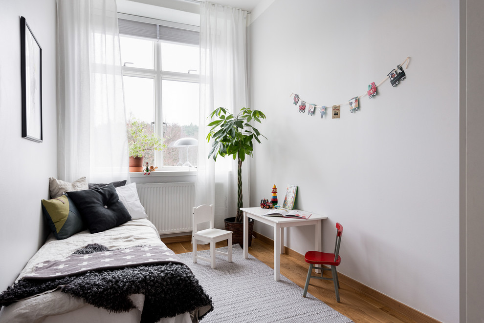Inspiration för ett mellanstort skandinaviskt könsneutralt barnrum kombinerat med sovrum och för 4-10-åringar, med grå väggar och mellanmörkt trägolv