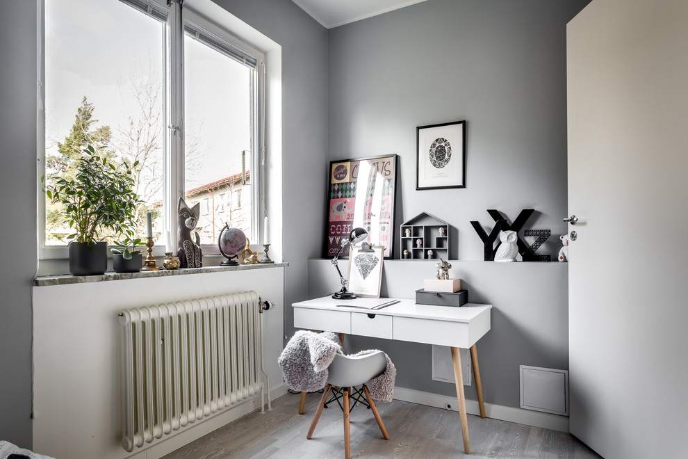 Aménagement d'une petite chambre neutre scandinave avec un bureau, un mur gris et un sol gris.