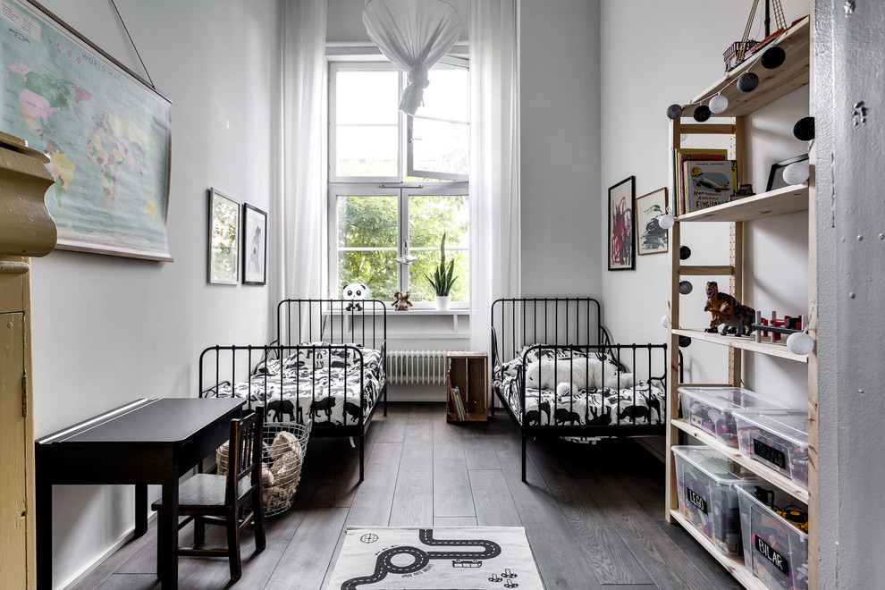 Inspiration for a medium sized scandinavian gender neutral children’s room in Stockholm with dark hardwood flooring and white walls.