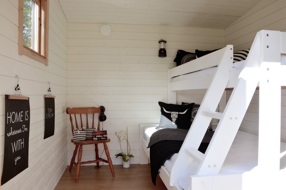 Foto på ett lantligt barnrum kombinerat med sovrum, med vita väggar och mellanmörkt trägolv