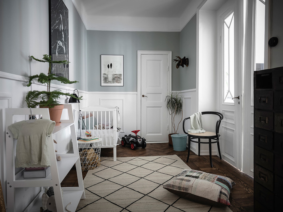 Medium sized scandinavian gender neutral toddler’s room in Gothenburg with grey walls, dark hardwood flooring and brown floors.