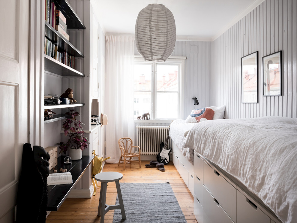 Scandi kids' bedroom in Gothenburg with grey walls, medium hardwood flooring, brown floors and tongue and groove walls.