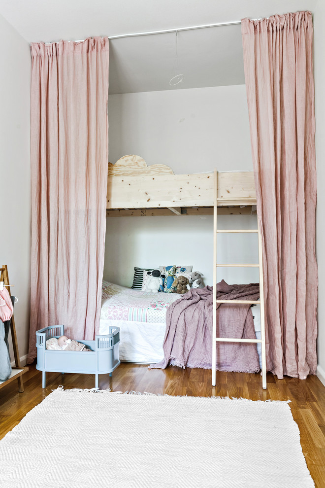Ejemplo de habitación de niña escandinava con suelo de madera clara y suelo beige