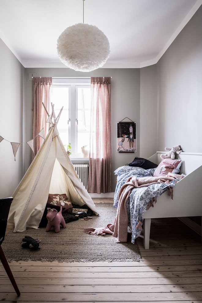 На фото: детская среднего размера в скандинавском стиле с спальным местом, серыми стенами, светлым паркетным полом и бежевым полом для ребенка от 4 до 10 лет, девочки с