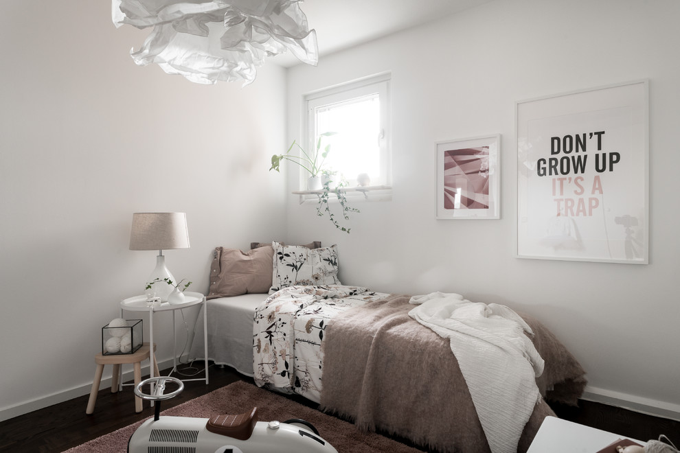 Modelo de dormitorio infantil de 4 a 10 años escandinavo de tamaño medio con paredes blancas, suelo de madera oscura y suelo marrón