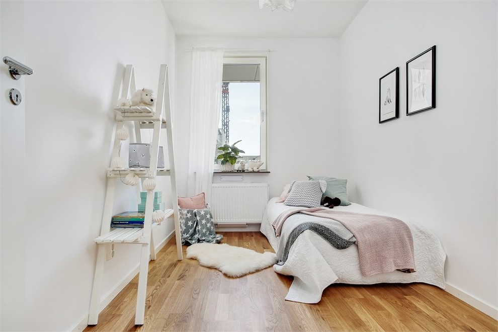 Inredning av ett minimalistiskt flickrum, med vita väggar, mellanmörkt trägolv och brunt golv