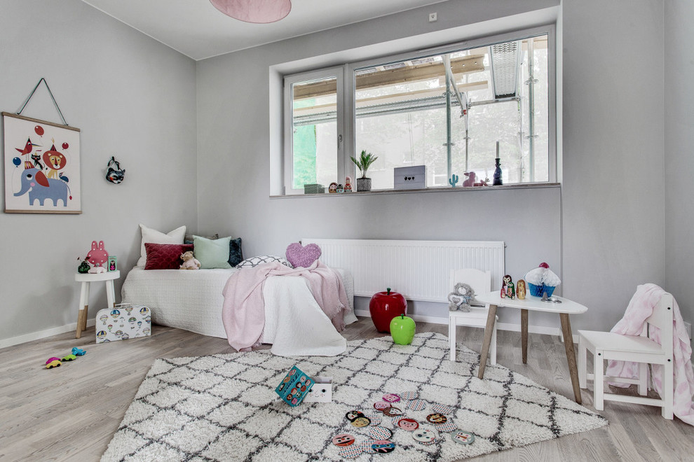 Cette photo montre une chambre d'enfant de 1 à 3 ans scandinave avec un mur gris et un sol beige.