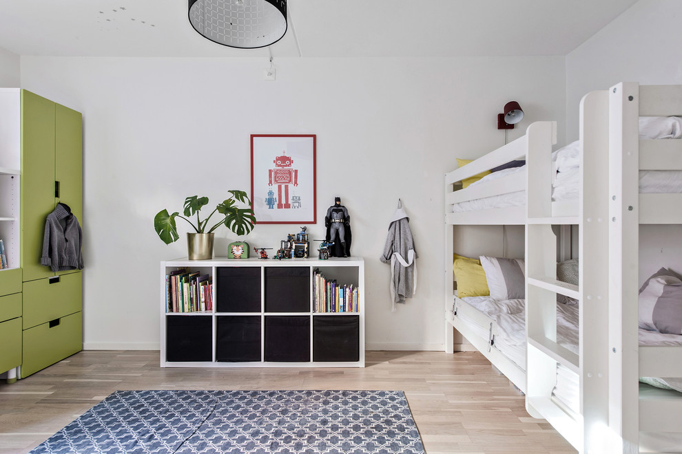 Exempel på ett nordiskt könsneutralt barnrum kombinerat med sovrum, med vita väggar, ljust trägolv och beiget golv