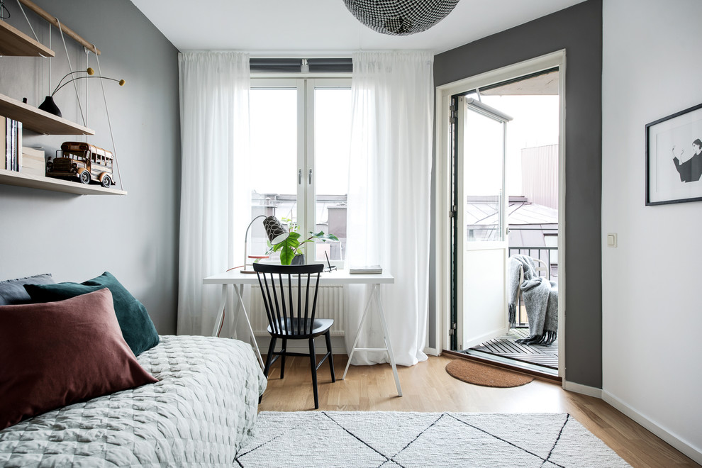 Photo of a scandinavian kids' bedroom in Gothenburg with grey walls, medium hardwood flooring and brown floors.