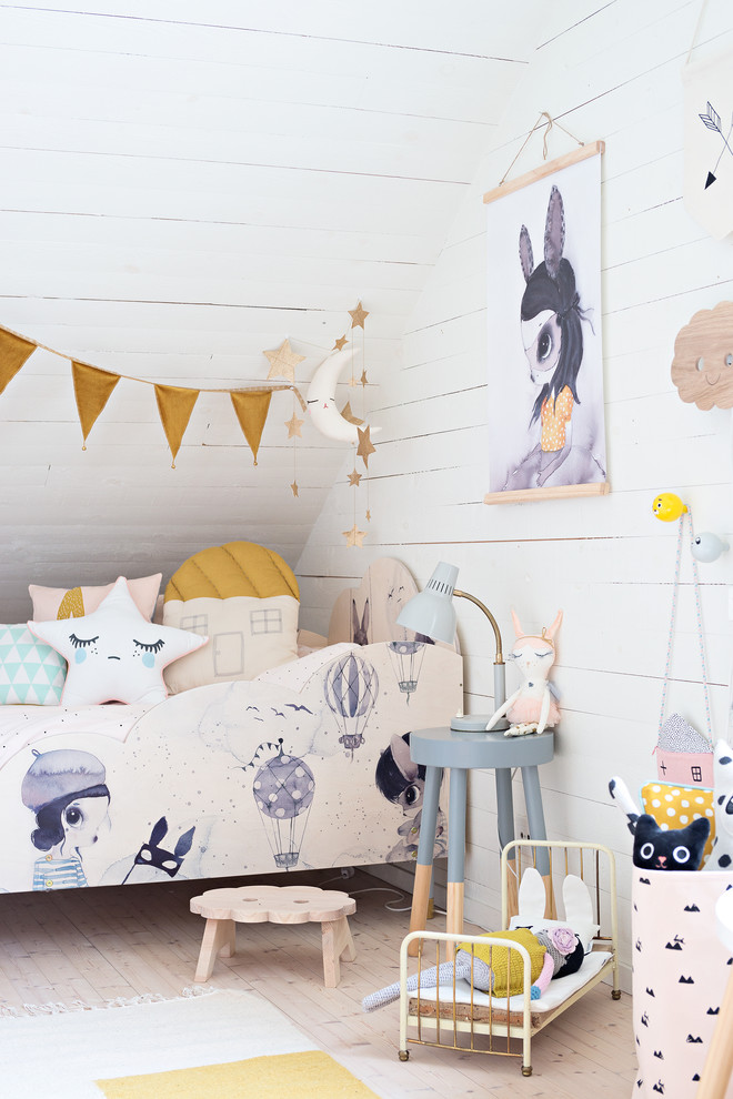 Example of a danish girl light wood floor kids' room design in Stockholm with white walls