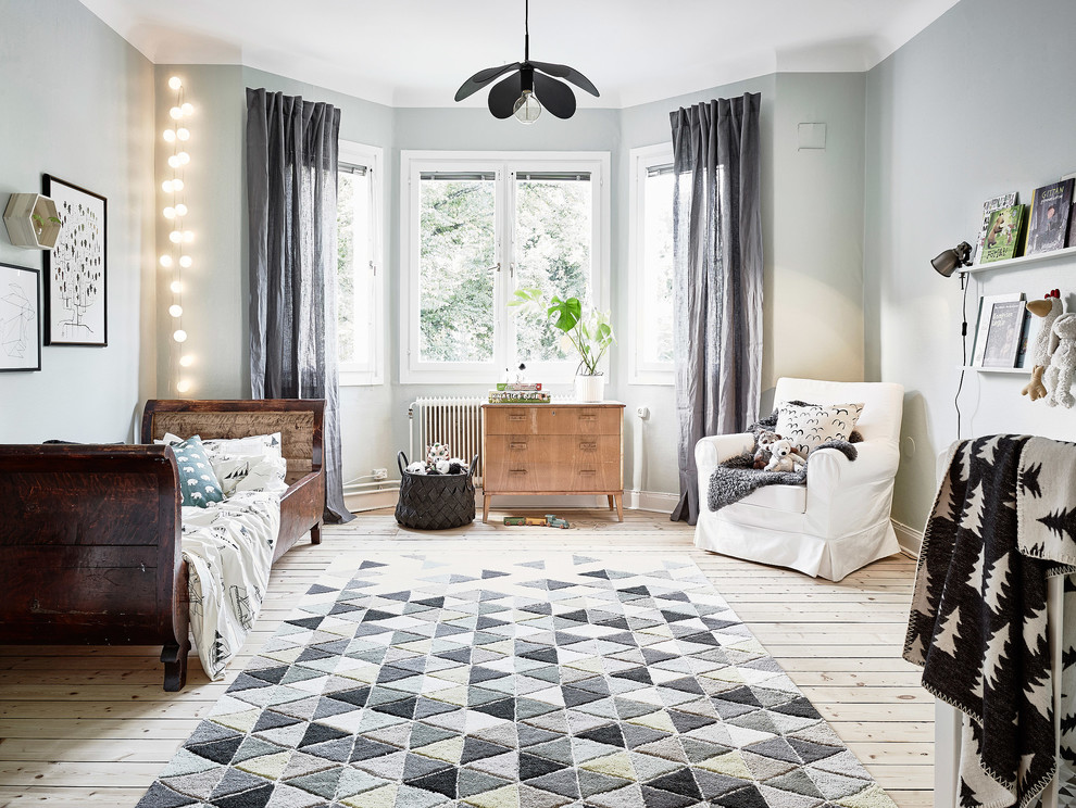 Design ideas for a large scandi gender neutral kids' bedroom in Gothenburg with blue walls and light hardwood flooring.