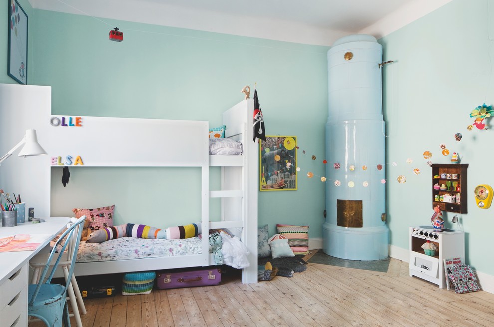 Inspiration för stora moderna könsneutrala barnrum kombinerat med sovrum och för 4-10-åringar, med blå väggar och ljust trägolv