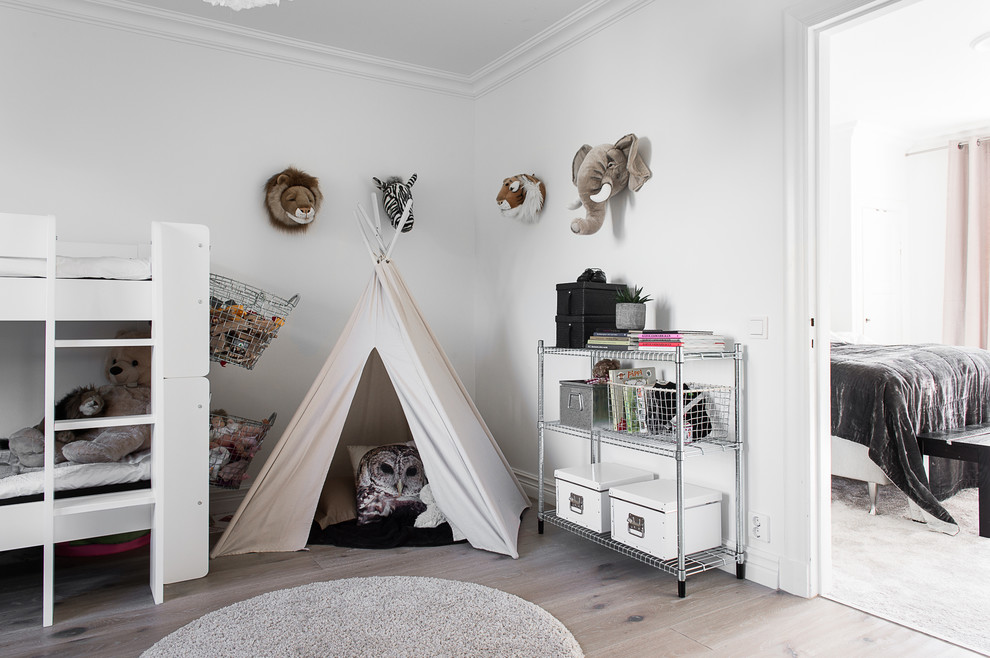 Kids' room - mid-sized traditional gender-neutral light wood floor kids' room idea in Gothenburg with white walls