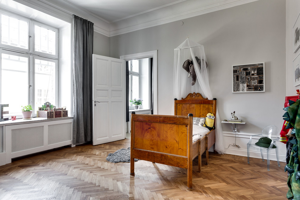 Ejemplo de dormitorio infantil de 4 a 10 años escandinavo grande con paredes grises y suelo de madera clara