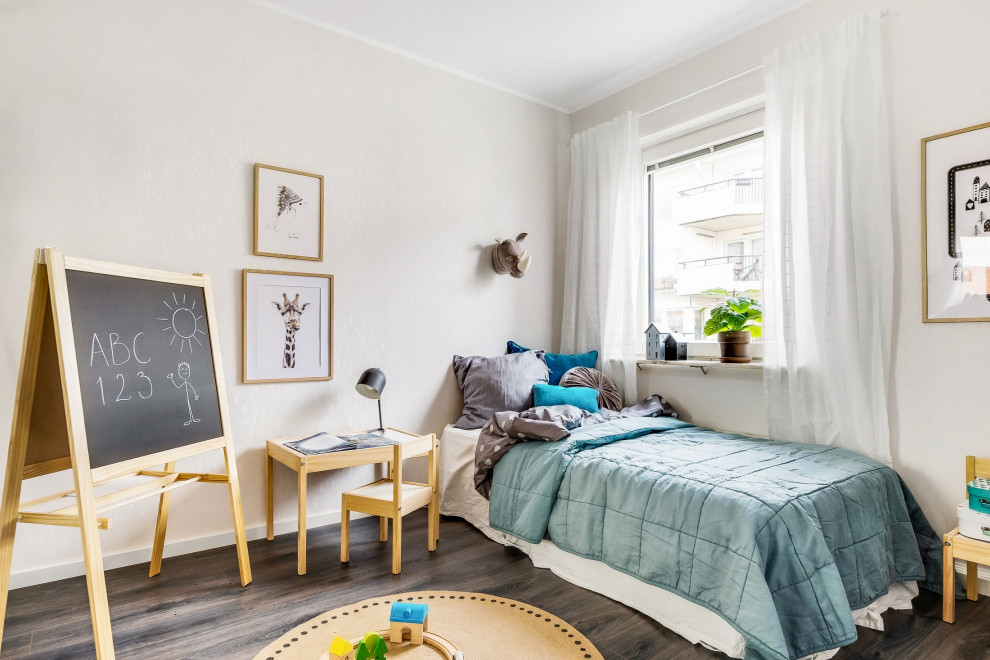 Immagine di una cameretta per bambini da 4 a 10 anni scandinava di medie dimensioni con pareti beige, parquet scuro e pavimento marrone