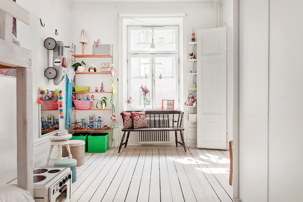 Immagine di una grande cameretta per bambini da 4 a 10 anni scandinava con pareti bianche, pavimento in legno verniciato e pavimento bianco