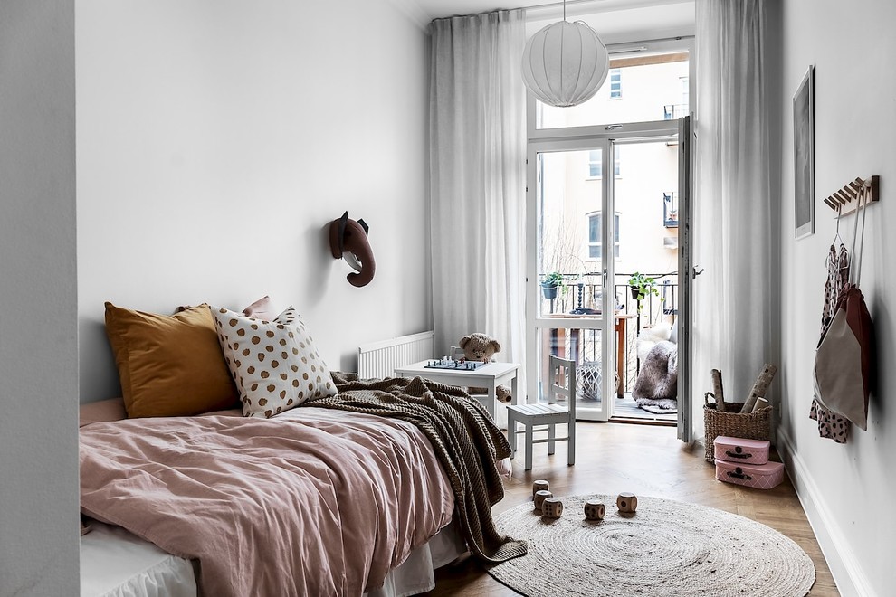 Nordisches Mädchenzimmer mit Schlafplatz, weißer Wandfarbe, braunem Holzboden und braunem Boden in Stockholm