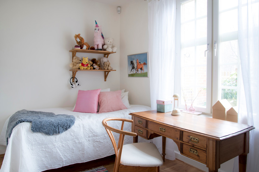 Cette photo montre une chambre d'enfant de 4 à 10 ans nature de taille moyenne avec un mur blanc et un sol en bois brun.