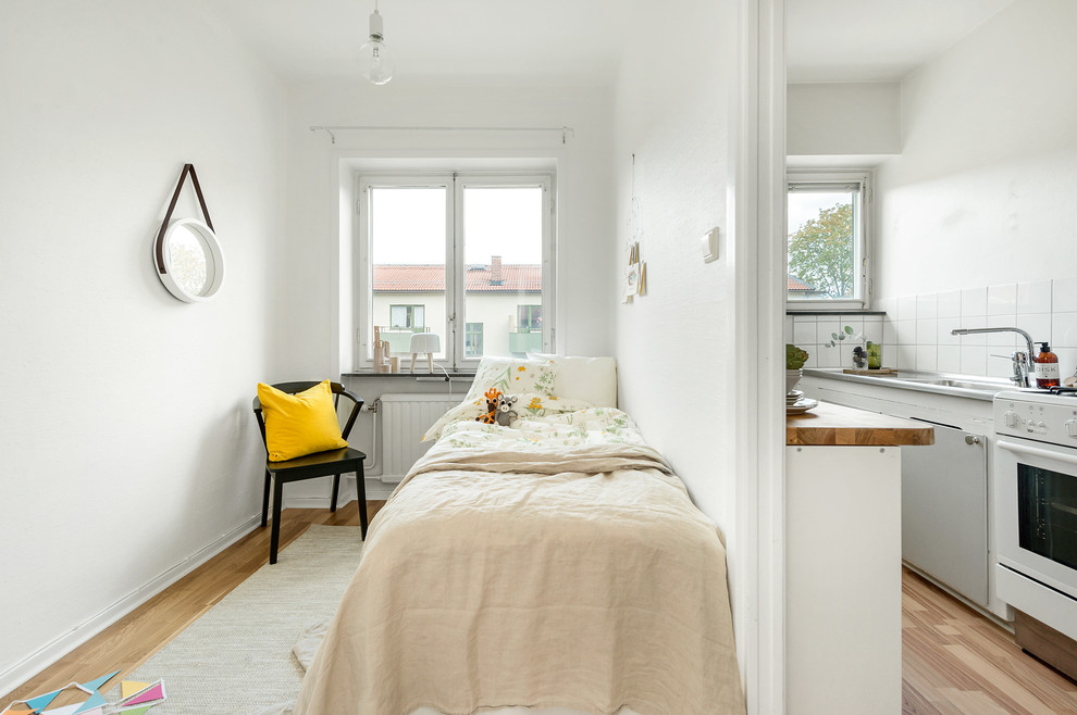 Idéer för ett litet minimalistiskt könsneutralt tonårsrum, med vita väggar och mellanmörkt trägolv