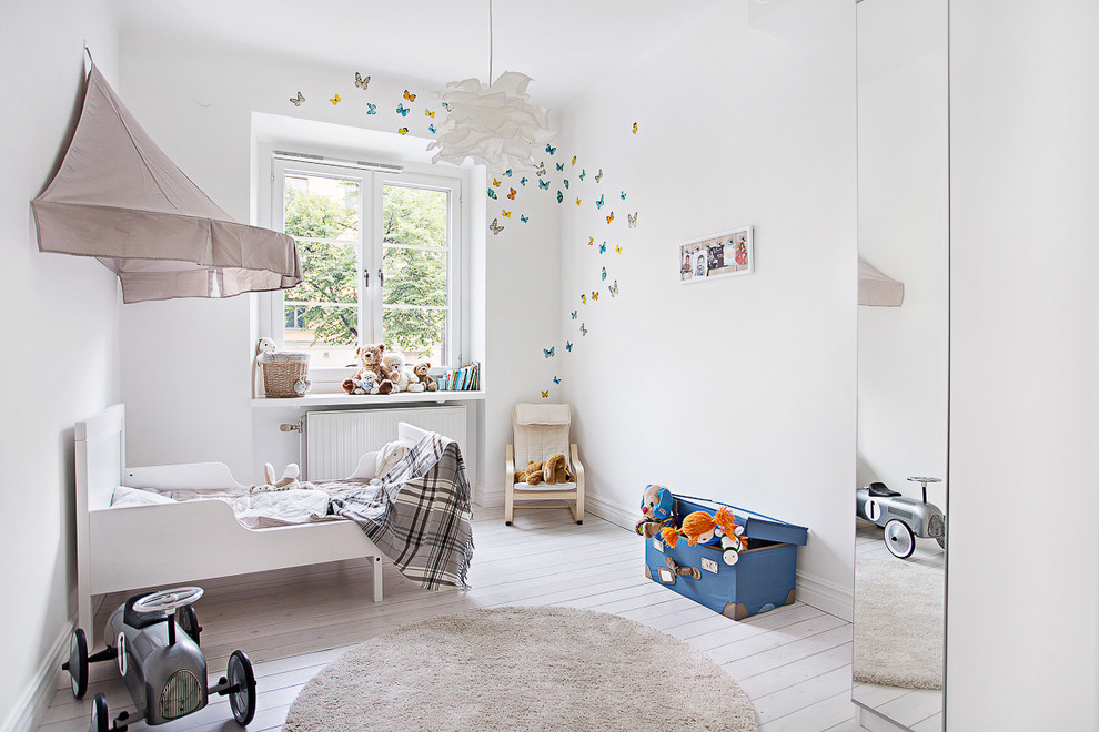 Bild på ett mellanstort nordiskt könsneutralt småbarnsrum kombinerat med sovrum, med vita väggar och målat trägolv