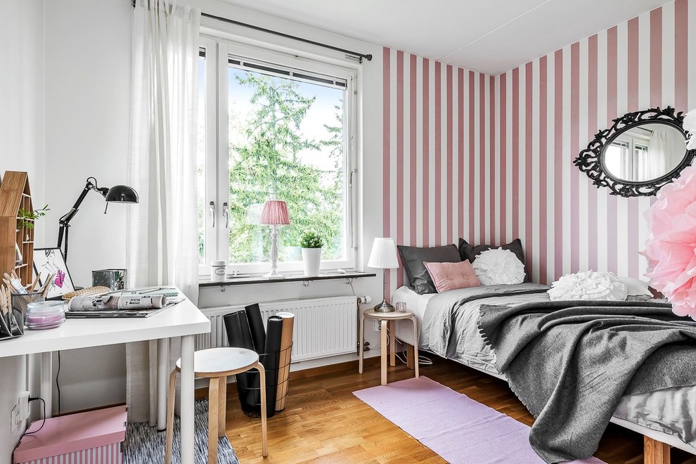 Design ideas for a scandinavian teen’s room for girls in Stockholm with pink walls and medium hardwood flooring.