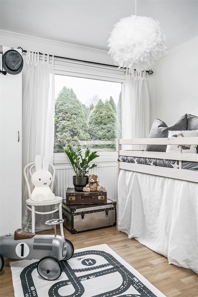 Inspiration för ett litet minimalistiskt barnrum för 4-10-åringar och kombinerat med sovrum, med vita väggar, mellanmörkt trägolv och brunt golv