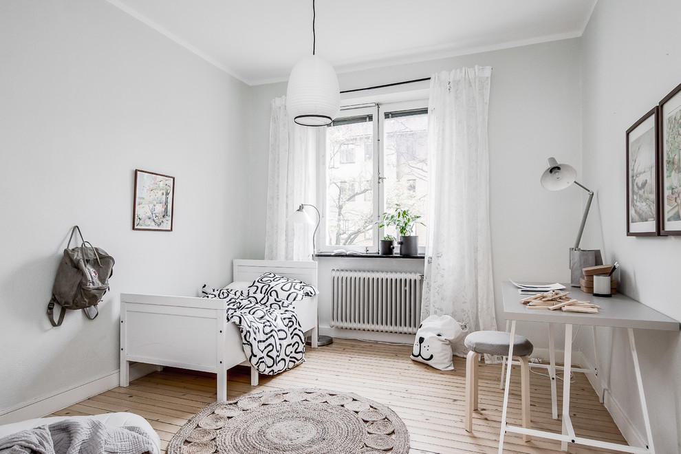 На фото: нейтральная детская в скандинавском стиле с спальным местом, серыми стенами, светлым паркетным полом и бежевым полом с