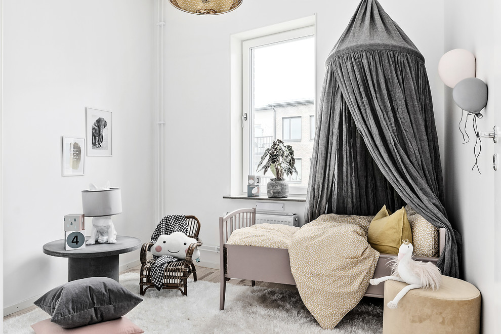Inspiration för ett minimalistiskt barnrum kombinerat med sovrum, med vita väggar, ljust trägolv och beiget golv