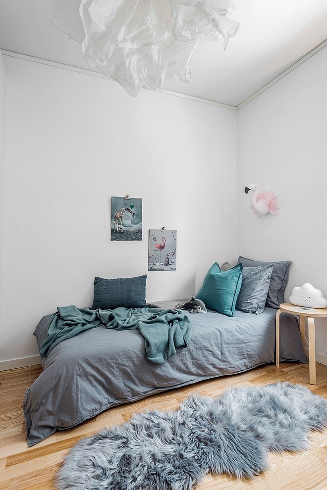 Idéer för nordiska flickrum kombinerat med sovrum och för 4-10-åringar, med vita väggar, ljust trägolv och beiget golv