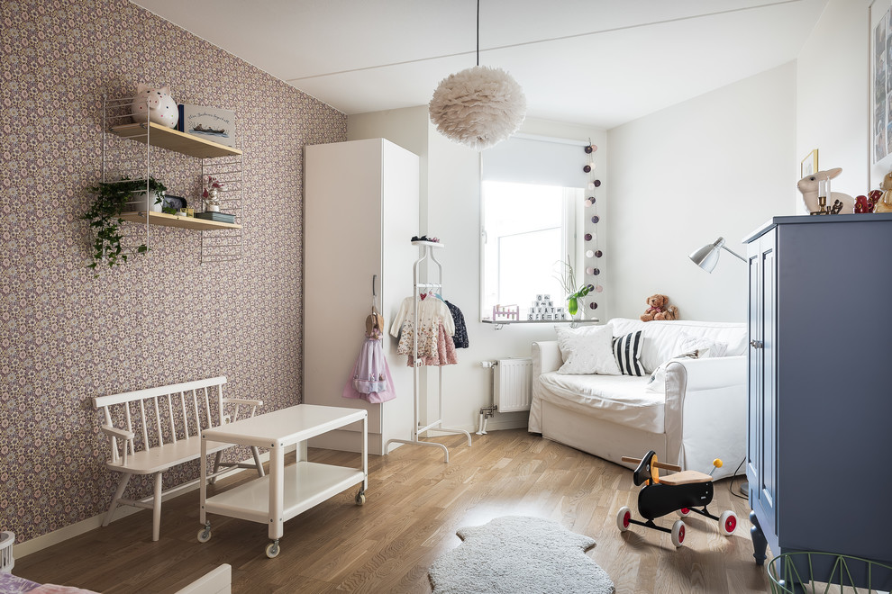 На фото: детская среднего размера в скандинавском стиле с спальным местом, фиолетовыми стенами, паркетным полом среднего тона и коричневым полом для ребенка от 1 до 3 лет, девочки