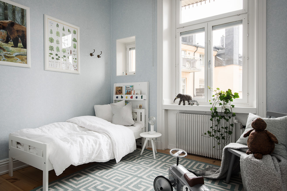 Inspiration för mellanstora nordiska pojkrum kombinerat med sovrum och för 4-10-åringar, med blå väggar, mellanmörkt trägolv och brunt golv
