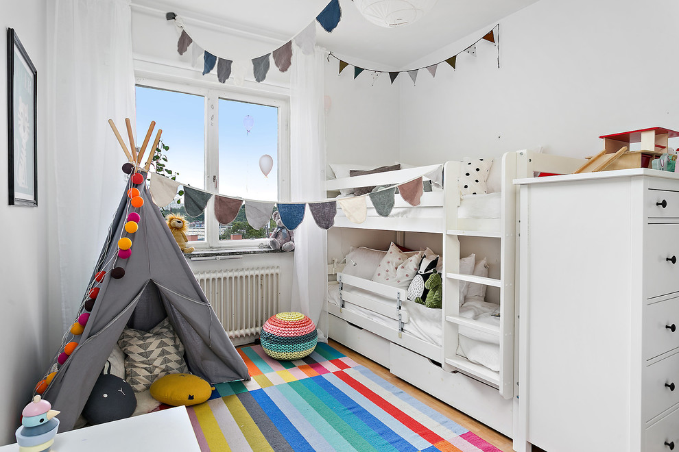 Bild på ett mellanstort skandinaviskt könsneutralt barnrum kombinerat med sovrum och för 4-10-åringar, med vita väggar