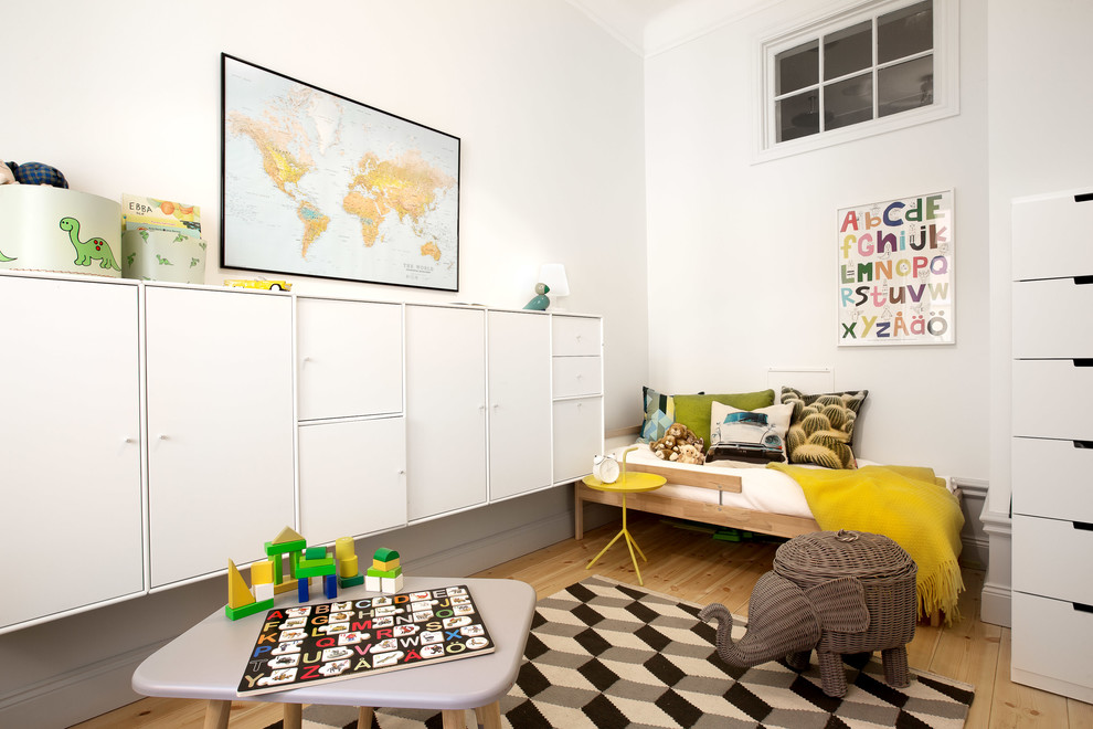 Idéer för ett modernt könsneutralt småbarnsrum kombinerat med lekrum, med vita väggar, mellanmörkt trägolv och beiget golv