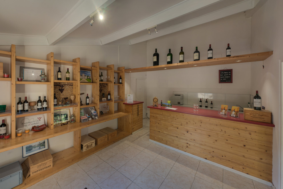 Modelo de bar en casa con fregadero campestre de tamaño medio con armarios abiertos, puertas de armario de madera clara y encimeras rojas