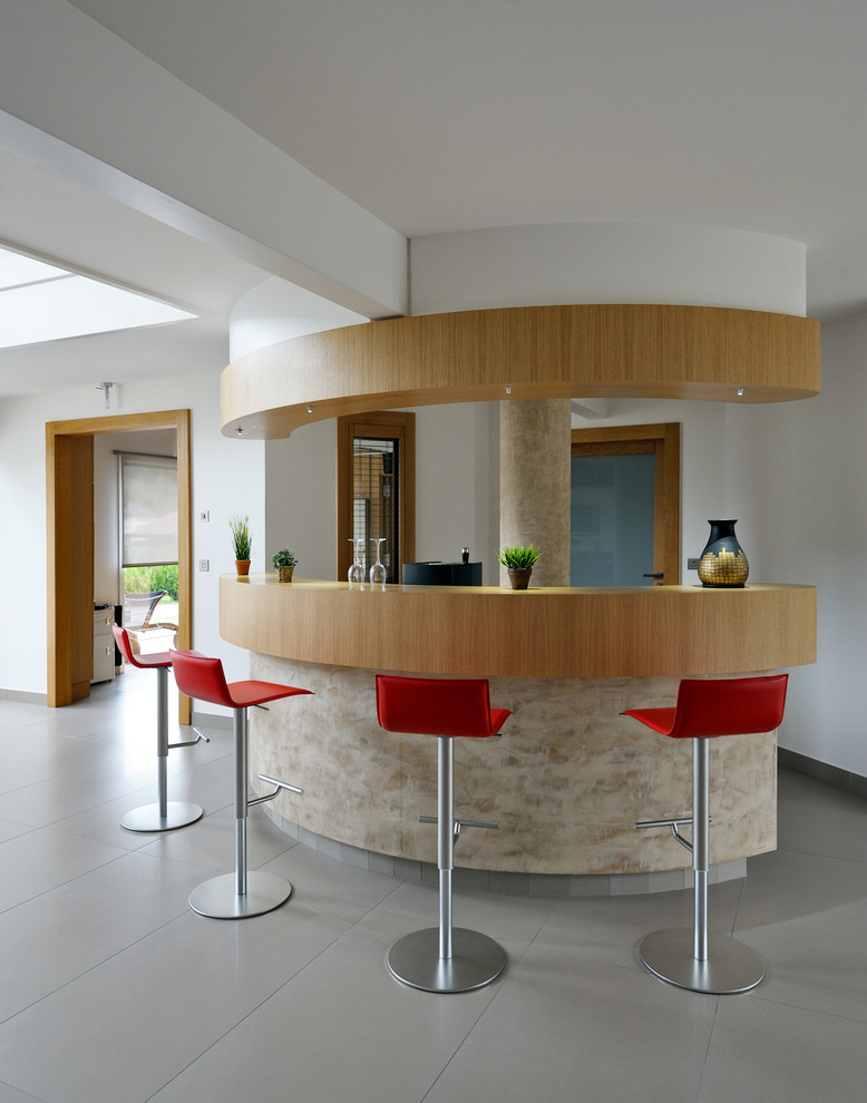 Стильный дизайн: домашний бар в современном стиле с барной стойкой, деревянной столешницей и полом из керамической плитки - последний тренд