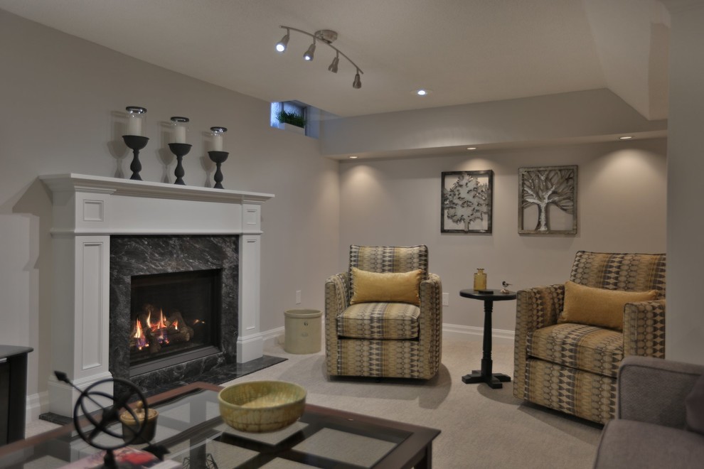 Basement - mid-sized transitional underground carpeted basement idea with beige walls and a standard fireplace