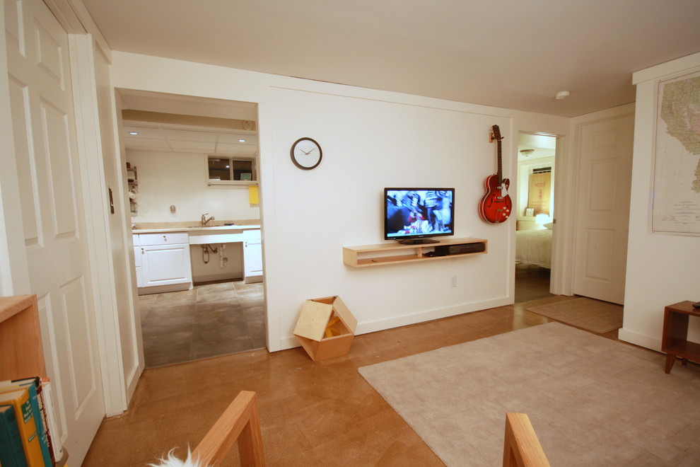 Kleines Modernes Untergeschoss mit weißer Wandfarbe und Betonboden in Sonstige