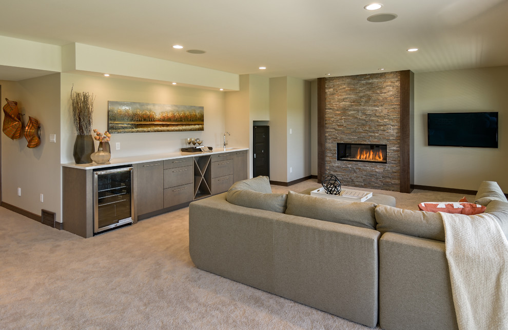 Photo of a large contemporary walk-out basement in Other with carpet, a ribbon fireplace, a stone fireplace surround, beige walls and beige floors.