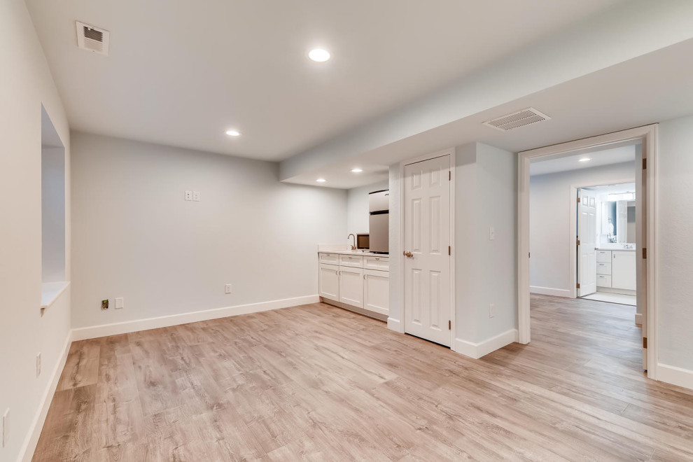 Mid-sized trendy look-out laminate floor basement photo in Denver with gray walls
