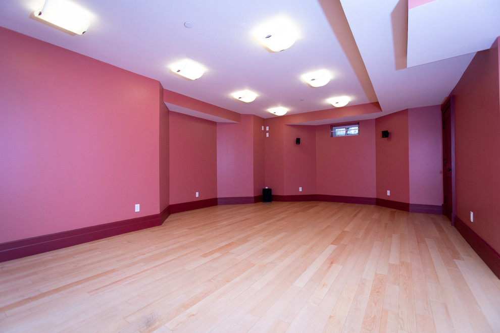 Imagen de sótano en el subsuelo clásico renovado grande con paredes rosas y suelo de madera clara