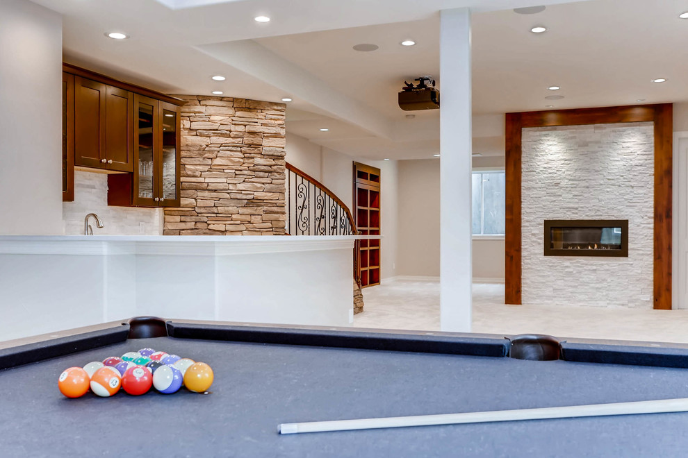 Photo of an expansive country fully buried basement in Denver with white walls, carpet, a standard fireplace, a stone fireplace surround and white floor.