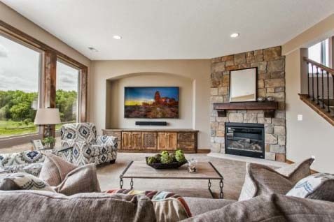 Large walk-out basement in Minneapolis with carpet, a standard fireplace and a stone fireplace surround.