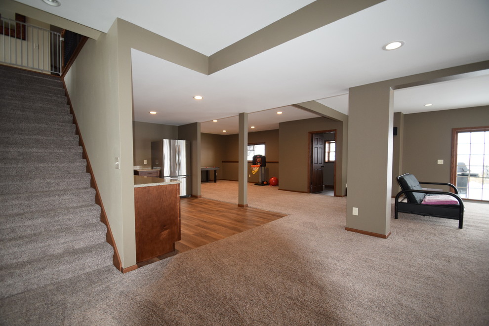 Inspiration for a mid-sized transitional walk-out carpeted basement remodel in Other with beige walls