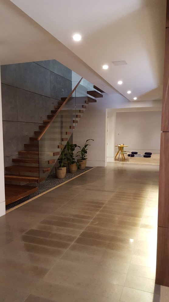 This is an example of a medium sized contemporary look-out basement in Toronto with white walls, light hardwood flooring, beige floors and no fireplace.