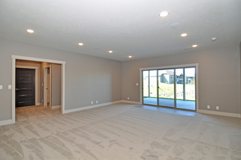 This is an example of a medium sized classic walk-out basement in Other with beige walls, carpet and no fireplace.