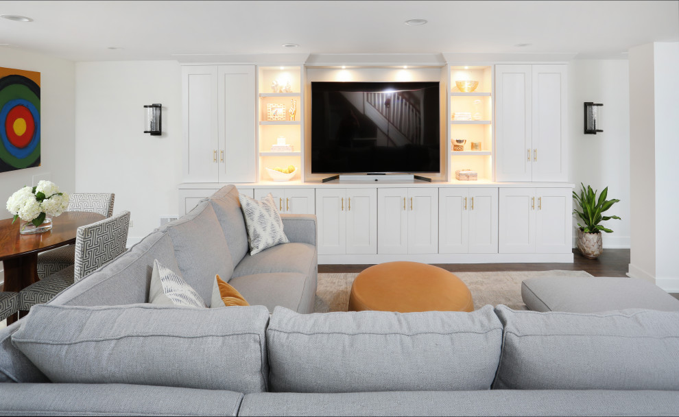 Идея дизайна: огромная гостиная комната в стиле неоклассика (современная классика) с белыми стенами, полом из ламината и коричневым полом