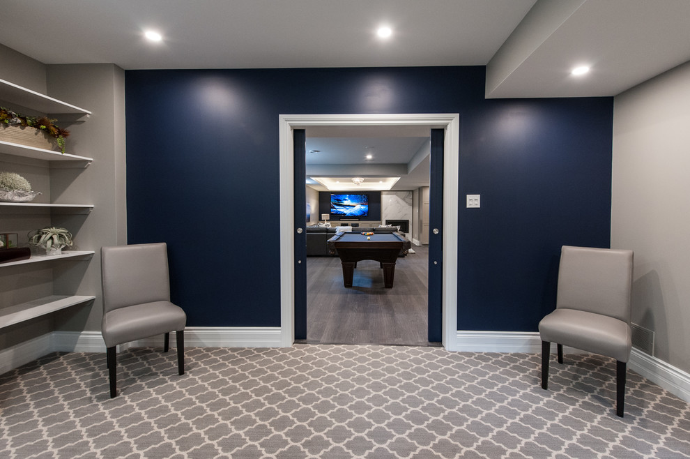 Klassisk inredning av en mellanstor källare utan ingång, med blå väggar, heltäckningsmatta och grått golv